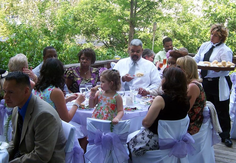 A group of people enjoys a catered meal at a festive outdoor gathering.