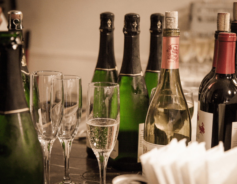 A collection of wine bottles and champagne flutes on a table.